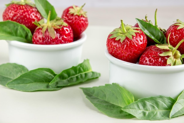 Ripe strawberries anf mint in a bowl on a table