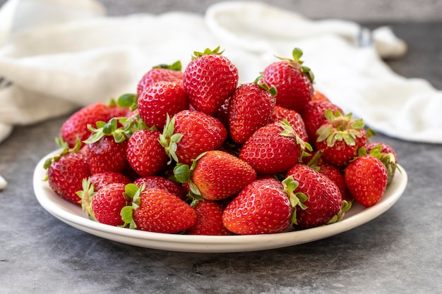 Ripe strawberries on a dark background Fresh strawberries on the plate Organic food close up