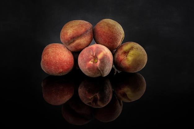 Ripe sweet peaches on black background