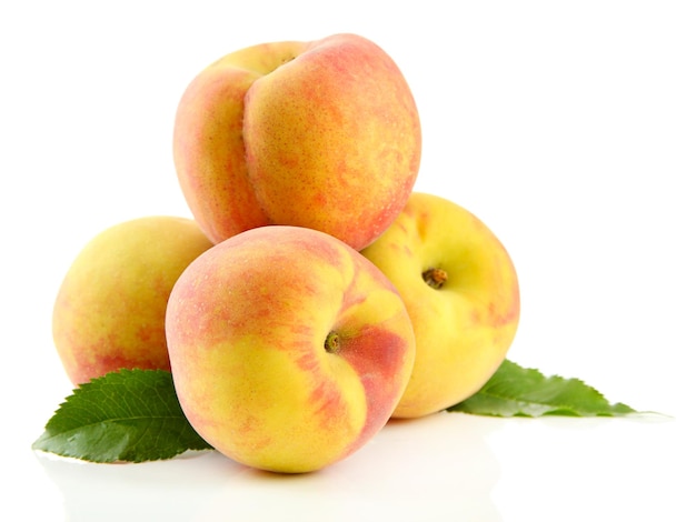 Ripe sweet peaches with leaves isolated on white