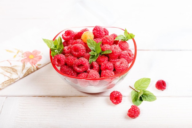 Ripe sweet raspberries in bowl on wooden table Close up top view high resolution product