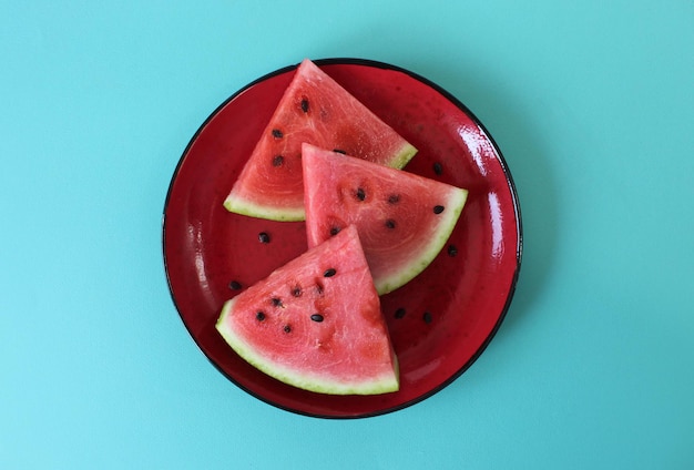 Ripe and sweet watermelon pieces on blue backrgound Top view Copy space Summer enriched or vitaminized vegan food