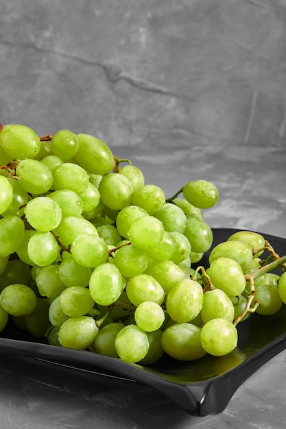 Ripe sweet white grapes bunch of grapes and grapes on a concrete gray background