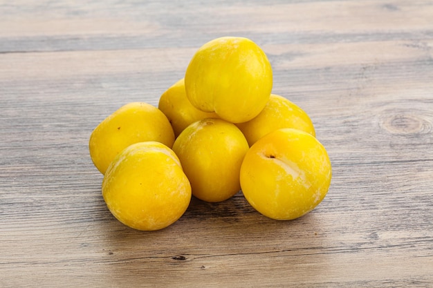 Ripe sweet yellow plum heap over background