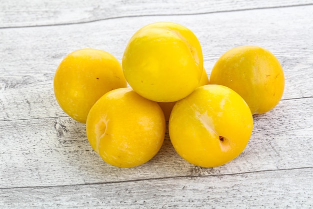 Ripe sweet yellow plum heap over background