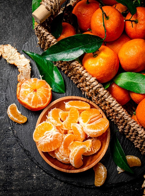 Ripe tangerines with leaves in a basket