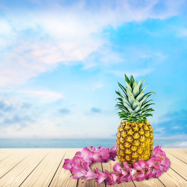 Ripe tasty pineapple and flowers isolated