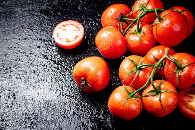 Ripe tomatoes on a branch and tomato halves