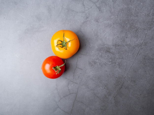 Ripe tomatoes on grey background with copy space