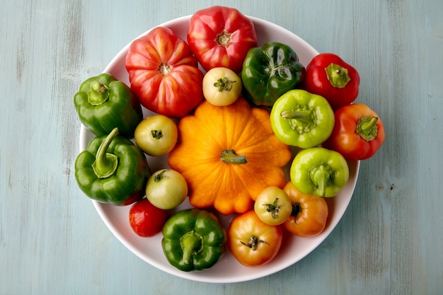 Ripe vegetables from the garden are laid out on a white plate. Harvesting