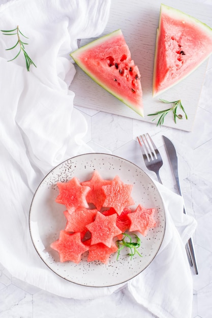 Ripe watermelon stars on a plate on the table Summer refreshment Top and vertical view