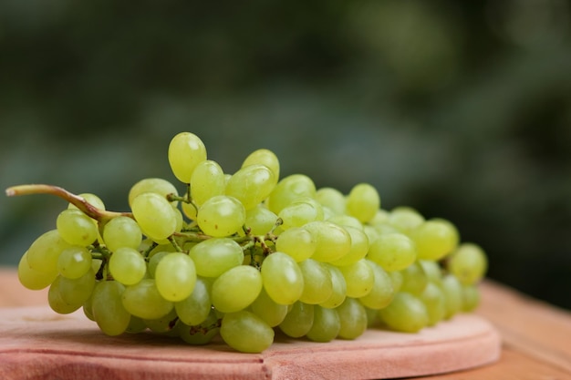 Ripe white grapes on a wooden board Shine Muscat Grape on blurred background on wooden table Closeup