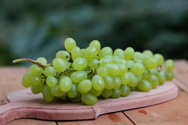 Ripe white grapes on a wooden board Shine Muscat Grape on blurred background on wooden table Closeup