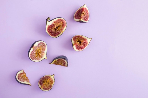 Ripe whole and cut blue figs with lavender on the purple backgroundTop view Copy space