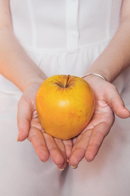 Ripe yellow apple in tender female hands