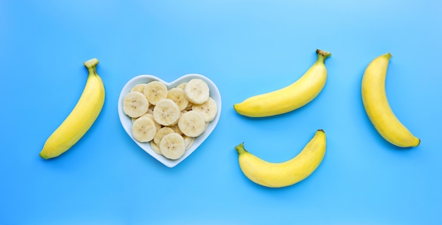 Ripe yellow bananas on blue background.