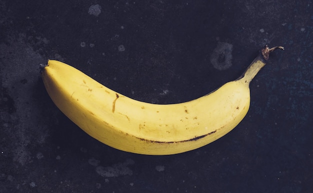 Ripe yellow bananas fruits bunch of ripe bananas with dark spots on a dark background