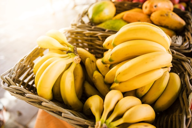 Ripe yellow bananas in wicker basket at fruit market store