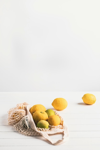 Ripe yellow lemons and limes on a white board and white background