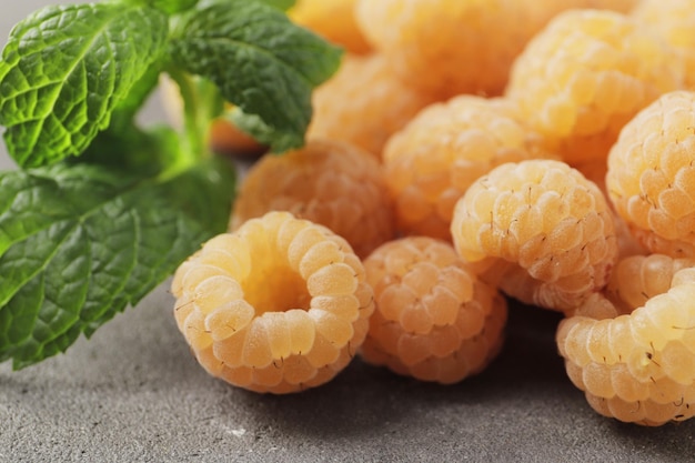 Ripe yellow raspberries on a marble background Closeup