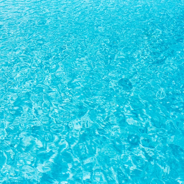 Ripple Water in swimming pool with sun reflection.