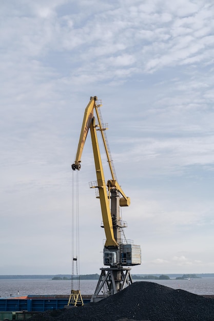 Rise tower crane over coastal terminal as charcoal is being loaded onto trains for transport