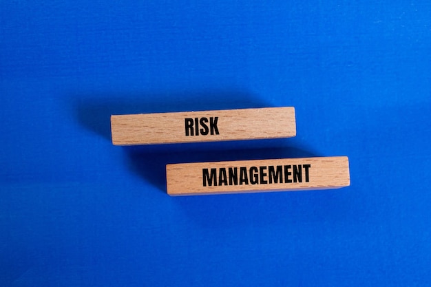 Photo risk management message written on wooden blocks with blue background conceptual risk management symbol copy space