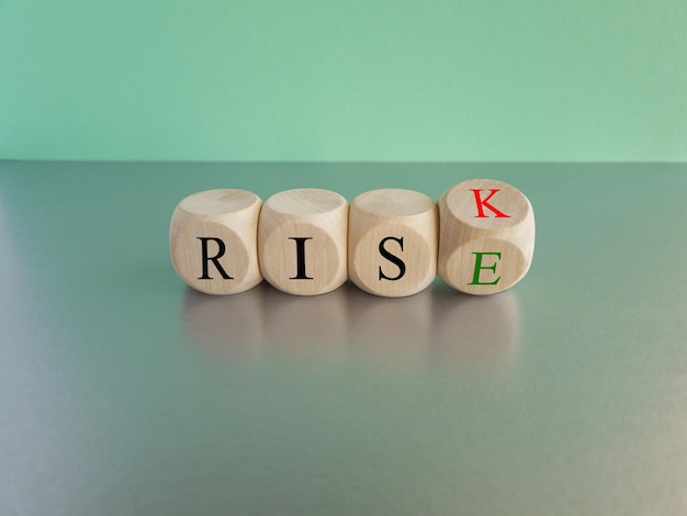 Risk vs rise symbol Turned a wooden cube and changes the word risk to rise