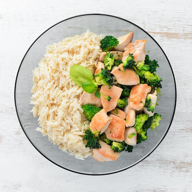 Risotto with chicken fillet and vegetables Top view On a white wooden background Free copy space