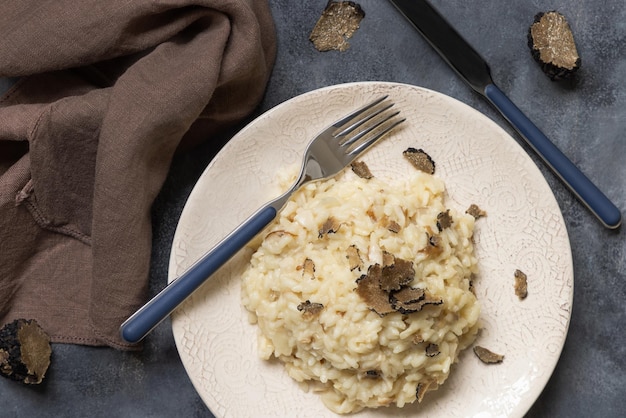 Risotto with porcini mushrooms and black truffles served in a plate top view gourmet cousine