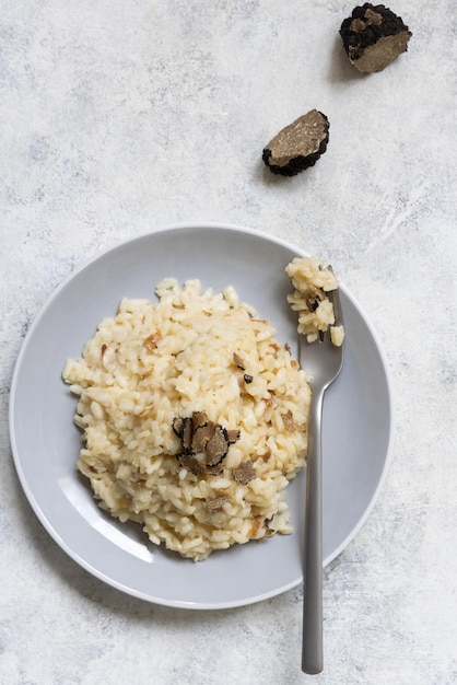 Risotto with porcini mushrooms and black truffles served in a plate top view gourmet cousine