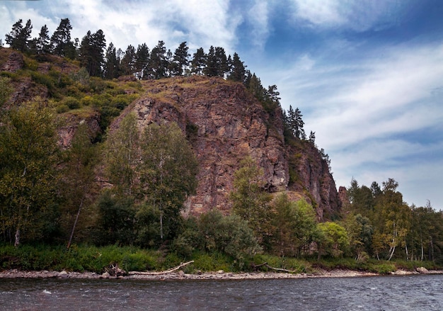 A river and forested mountains along its banks Summer landscape Travel hiking healthy lifestyle