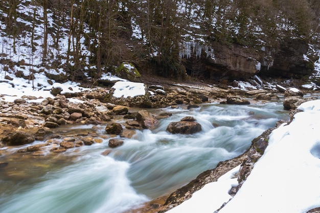 River in the mountains. mountainous area. photo on a long exposure, cloudy day. waterfalls in the mountains in the forest, winter landscape of mountain rivers