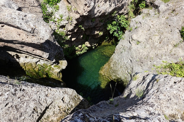 A river in the mountains with a green pool