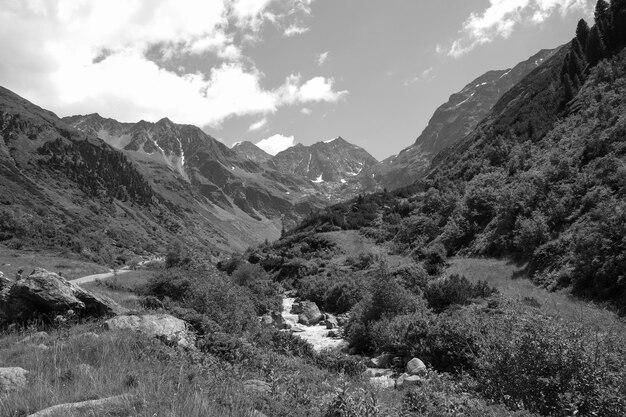 Photo a river runs through a valley with a mountain in the background