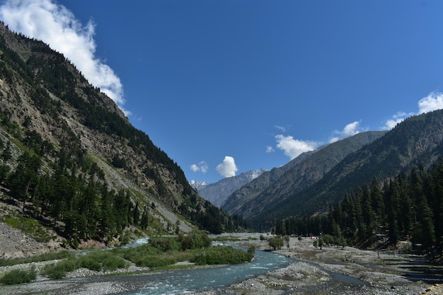 Photo a river runs through a valley with mountains in the background.