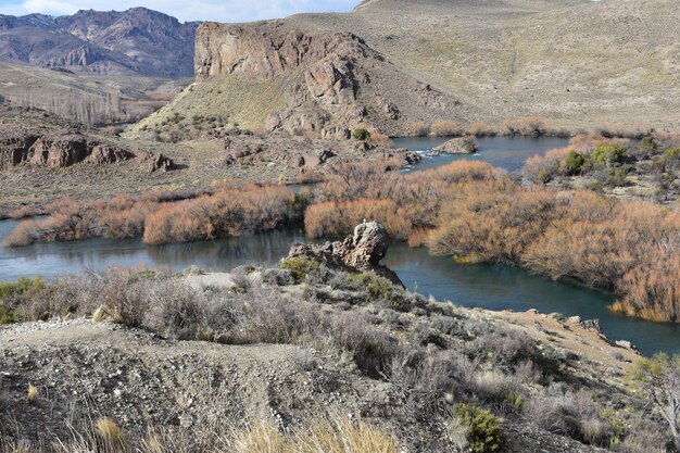 a river with a mountain in the background and a river with a mountain in the background