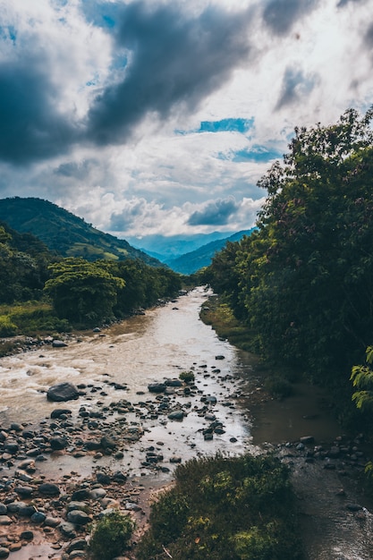 a river with mountains an clouds