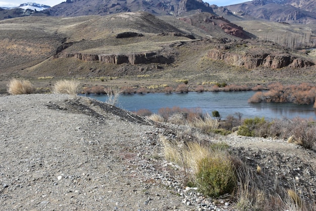 a river with a river running through it and a mountain in the background