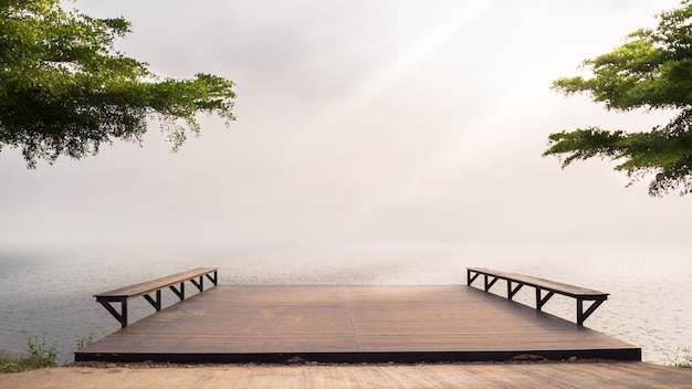 The river and wooden pier stretching into the lake at dawn in the morning.