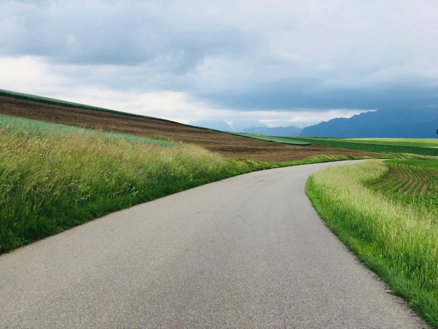 Photo road amidst field against sky