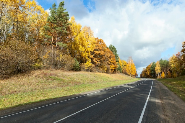 Road in the autumn season photographed for road vehicles in the autumn season, trees with yellowed leaves,