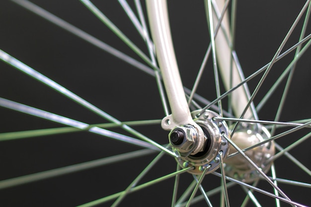 Road bike in the workshop Road bike wheel on a black background New fashionable beautiful bike Means for movement for active people Healthy life