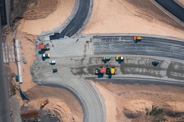 Road construction of wide asphalt road with help of road transport equipment top view