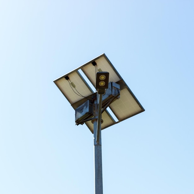 Road lamp with small solar panel on blue sky background