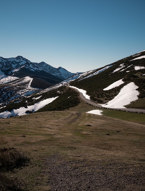 Road landscape between snowcapped mountains vertical wallpaper