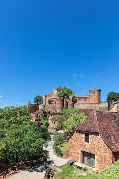 Road leading through small village to fortress Chateau de Castelnau Bretenoux Prudhomat France