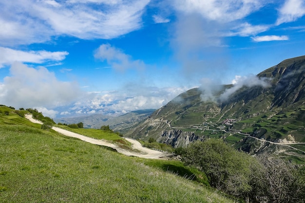 A road in the mountains of Dagestan with large mountains in the background and clouds Russia