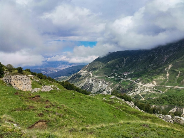 A road in the mountains of Dagestan with large mountains in the background and clouds Russia