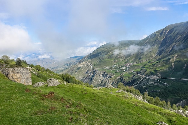 A road in the mountains of Dagestan with large mountains in the background and clouds Russia